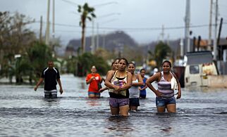People walk on a flooded street in the aftermath of Hurricane Maria in San Juan, Puerto Rico on September 22, 2017.
Puerto Rico battled dangerous floods Friday after Hurricane Maria ravaged the island, as rescuers raced against time to reach residents trapped in their homes and the death toll climbed to 33. Puerto Rico Governor Ricardo Rossello called Maria the most devastating storm in a century after it destroyed the US territory's electricity and telecommunications infrastructure.
/ AFP PHOTO / Ricardo ARDUENGO